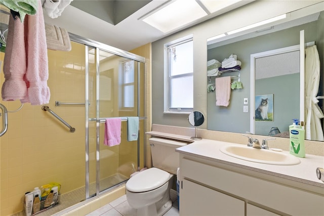 bathroom featuring a shower with door, vanity, toilet, and tile patterned floors