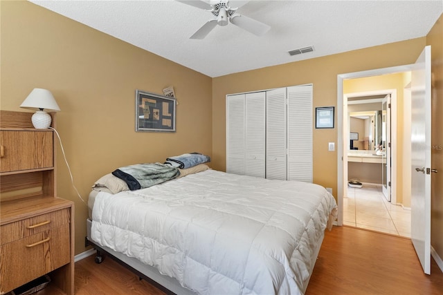 bedroom featuring a closet, ceiling fan, a textured ceiling, and hardwood / wood-style floors