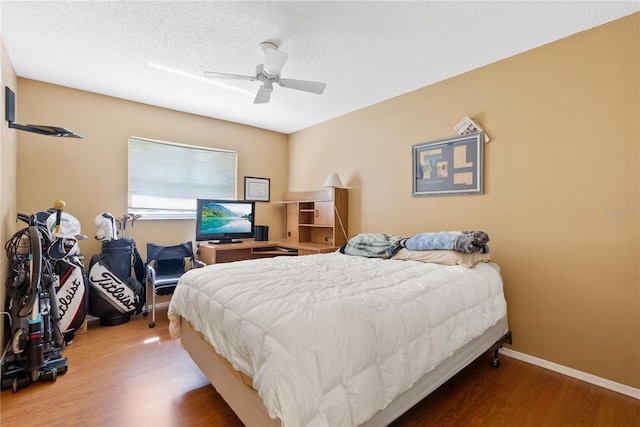 bedroom featuring a textured ceiling, wood-type flooring, and ceiling fan