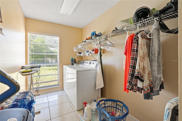 clothes washing area with a textured ceiling, light tile patterned flooring, and washing machine and dryer