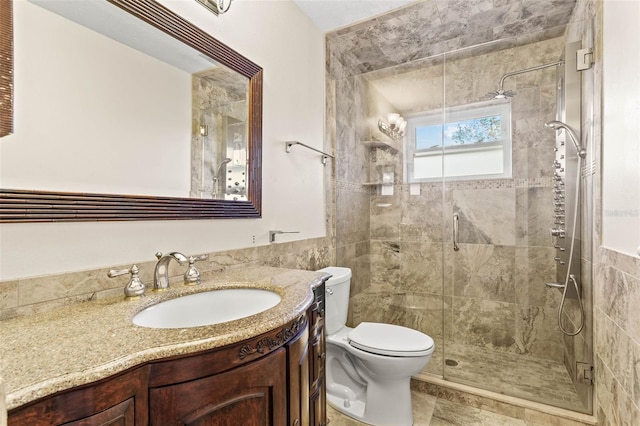 bathroom with tile walls, vanity, toilet, and walk in shower