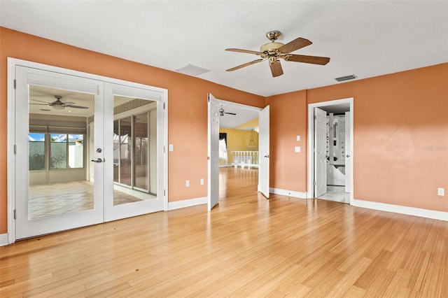 unfurnished room with french doors, ceiling fan, a textured ceiling, and light wood-type flooring