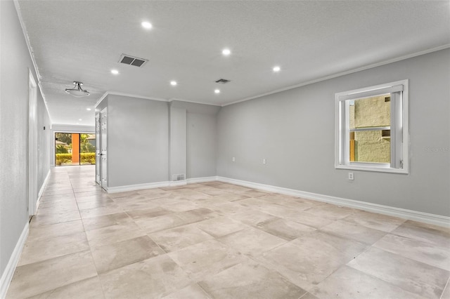 spare room featuring ornamental molding and a textured ceiling