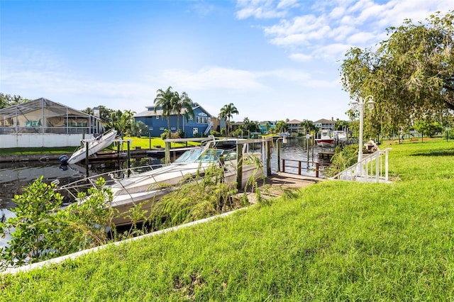 dock area featuring a water view, a lanai, and a yard