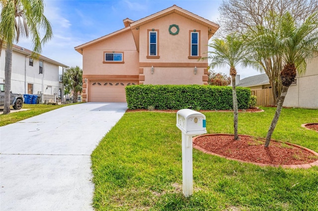 view of front of house with driveway, a front yard, stucco siding, fence, and an attached garage