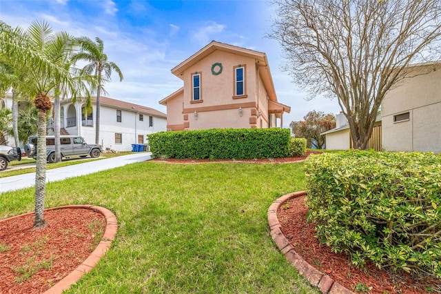 view of front of home with stucco siding and a front lawn