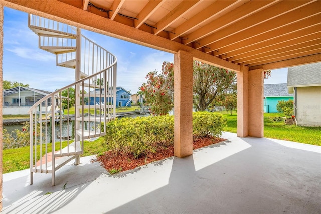 view of patio featuring a water view, boat lift, and a dock