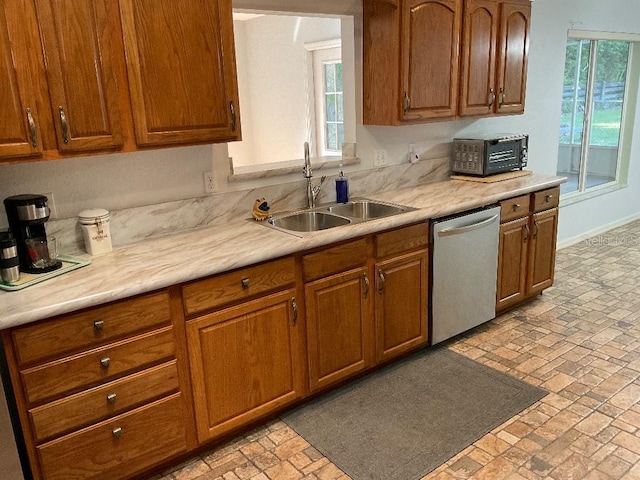 kitchen featuring stainless steel dishwasher, sink, and plenty of natural light