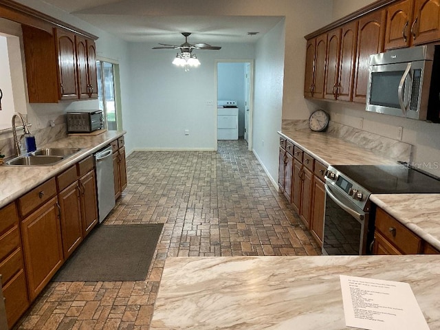 kitchen featuring sink, appliances with stainless steel finishes, ceiling fan, and washer / clothes dryer