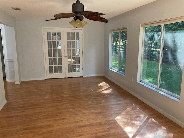 empty room with hardwood / wood-style floors, french doors, and ceiling fan