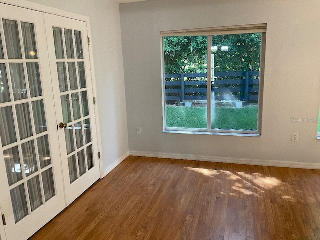 unfurnished room with french doors and dark hardwood / wood-style flooring