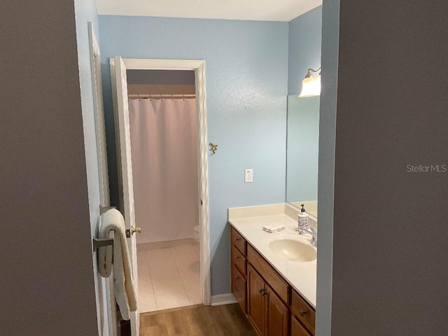 bathroom with vanity, a shower with shower curtain, wood-type flooring, and toilet