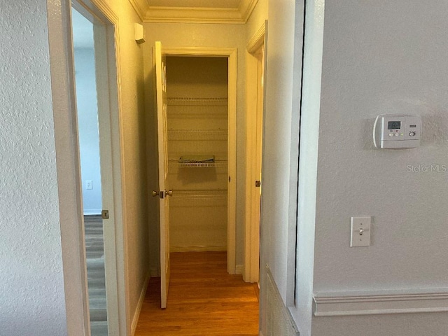 hallway featuring ornamental molding and hardwood / wood-style flooring