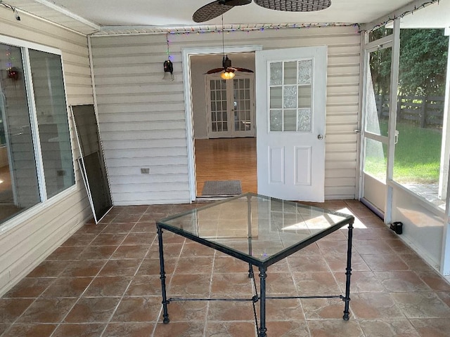 unfurnished sunroom with plenty of natural light and ceiling fan