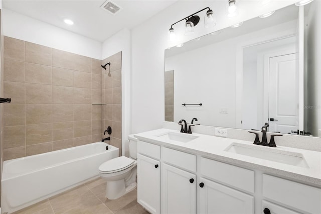 full bathroom with vanity, tiled shower / bath combo, toilet, and tile patterned flooring