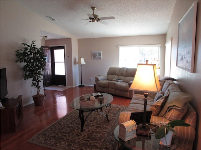 living room with a textured ceiling, a healthy amount of sunlight, and dark hardwood / wood-style flooring