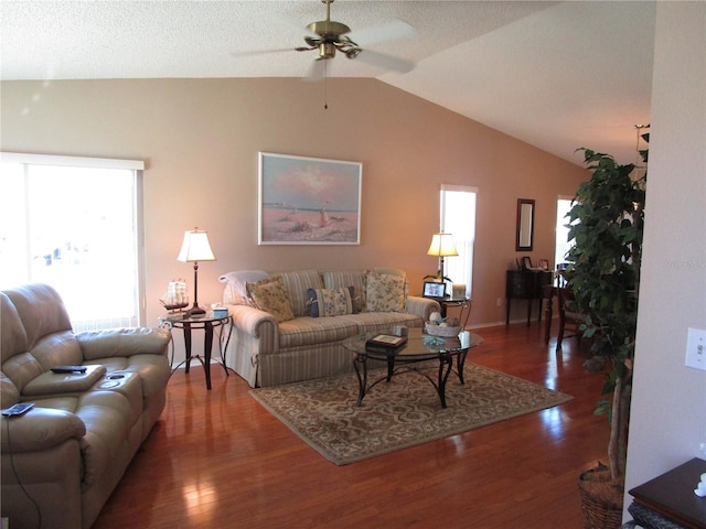 living room with lofted ceiling, dark hardwood / wood-style floors, and ceiling fan