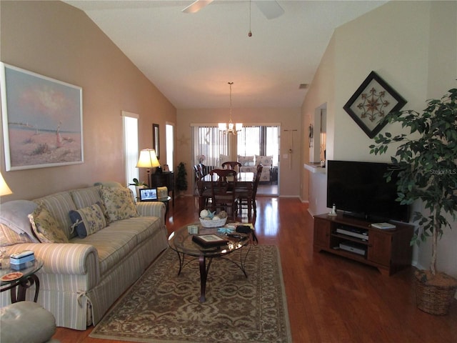 living room with lofted ceiling, dark wood-type flooring, and ceiling fan with notable chandelier