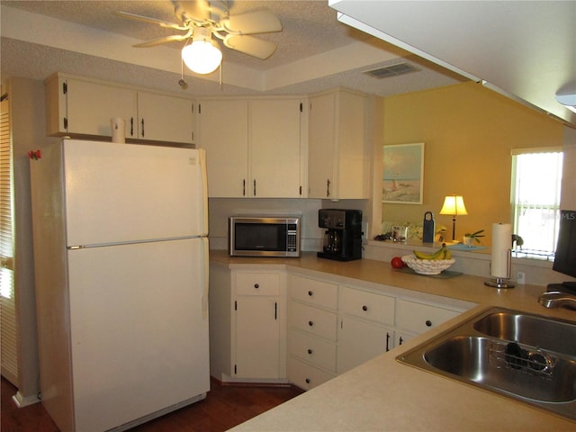 kitchen featuring dark hardwood / wood-style floors, white refrigerator, white cabinets, a textured ceiling, and ceiling fan