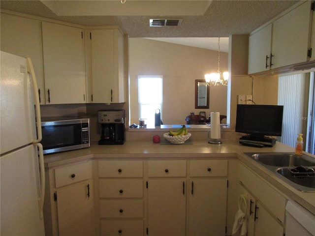 kitchen featuring sink, hanging light fixtures, white cabinets, an inviting chandelier, and white refrigerator