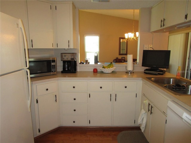 kitchen with lofted ceiling, white cabinets, decorative light fixtures, and white appliances