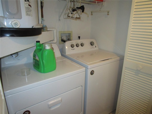 clothes washing area featuring washing machine and dryer and water heater