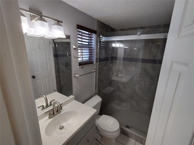 bathroom with a textured ceiling, vanity, toilet, and a shower with shower door