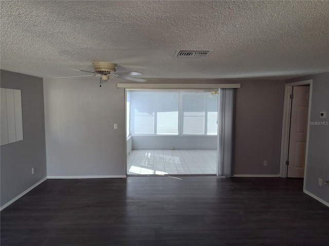 empty room with dark hardwood / wood-style floors, ceiling fan, and a textured ceiling