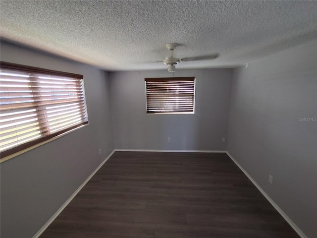 spare room featuring ceiling fan, dark wood-type flooring, and a textured ceiling