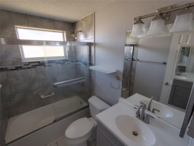 full bathroom with vanity, toilet, bath / shower combo with glass door, and a textured ceiling