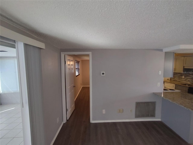 unfurnished living room featuring a textured ceiling, sink, and dark wood-type flooring