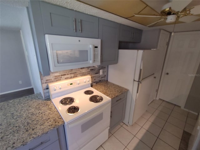 kitchen featuring ceiling fan, light stone countertops, backsplash, white appliances, and light tile patterned floors