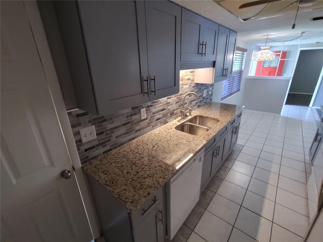 kitchen featuring light stone countertops, backsplash, white dishwasher, sink, and light tile patterned floors