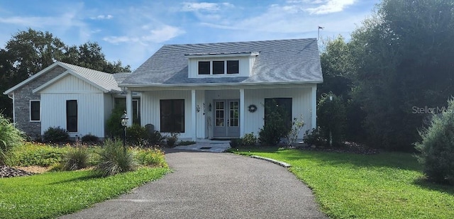 bungalow-style home with covered porch and a front yard