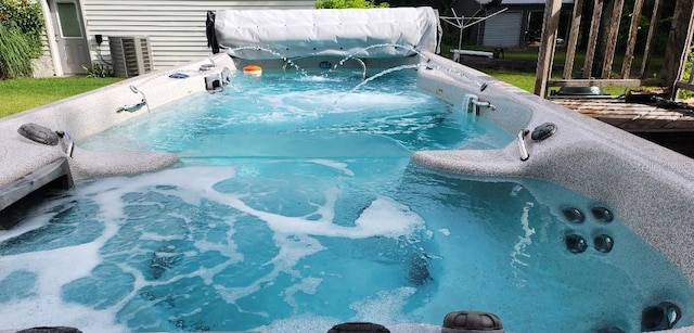 view of pool with a hot tub and central AC unit