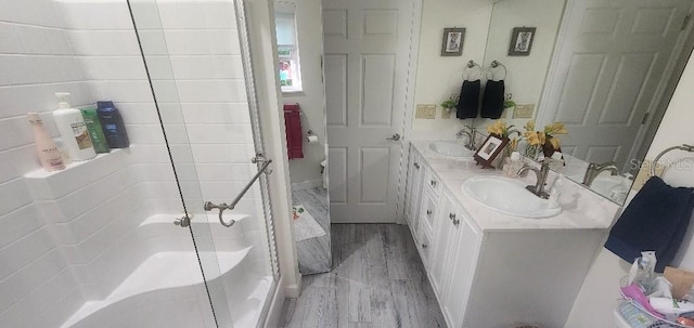 bathroom featuring a shower with door, vanity, and wood-type flooring