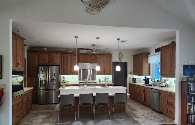 kitchen with sink, a center island, stainless steel appliances, pendant lighting, and a breakfast bar area