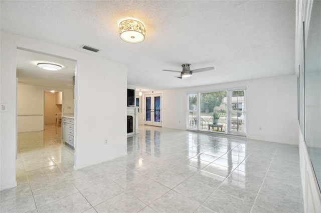 tiled spare room with a textured ceiling and ceiling fan