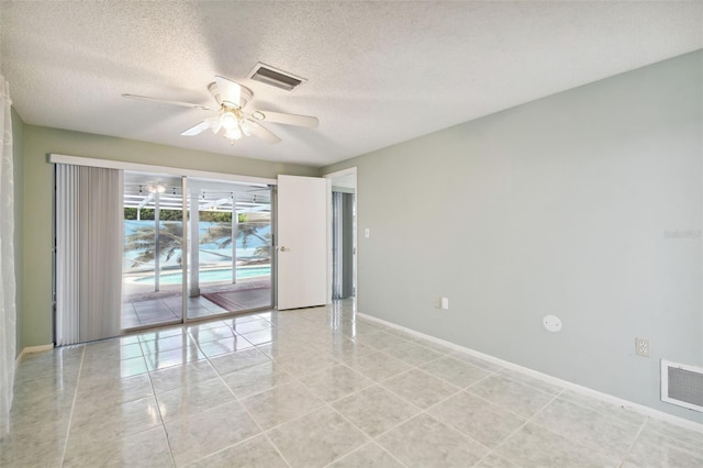 tiled empty room with a textured ceiling and ceiling fan