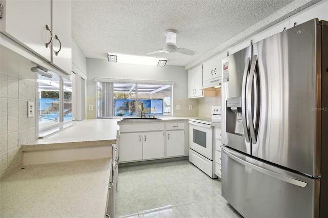 kitchen featuring white cabinetry, stainless steel fridge, white electric stove, and backsplash