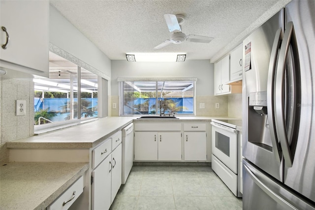 kitchen featuring decorative backsplash, white cabinets, white appliances, and ceiling fan