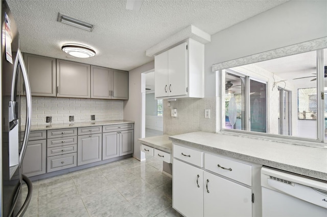 kitchen with ceiling fan, white dishwasher, decorative backsplash, and stainless steel fridge