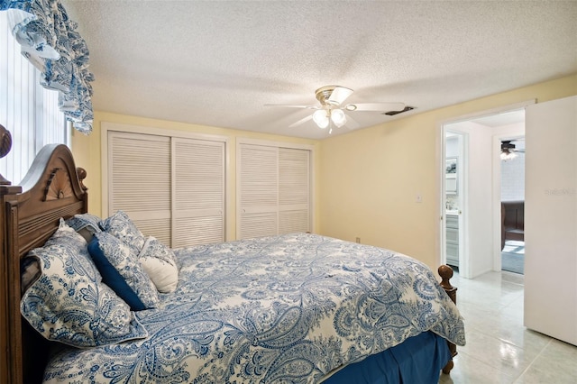 tiled bedroom featuring ceiling fan, a textured ceiling, and ensuite bathroom