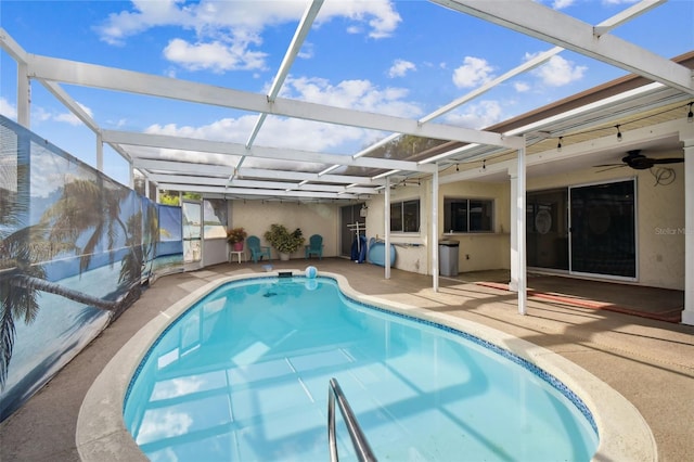 view of pool with a patio area, glass enclosure, and ceiling fan