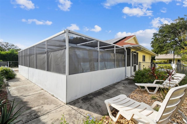 view of home's exterior featuring a patio area and glass enclosure