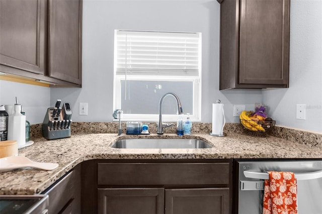 kitchen with stainless steel dishwasher, dark brown cabinetry, and sink