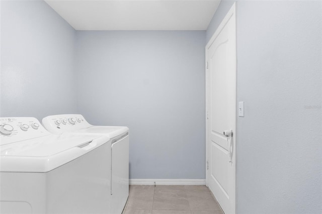 laundry room featuring light tile patterned flooring and washing machine and clothes dryer