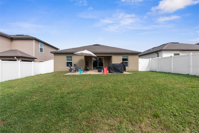 back of property with a yard and a patio