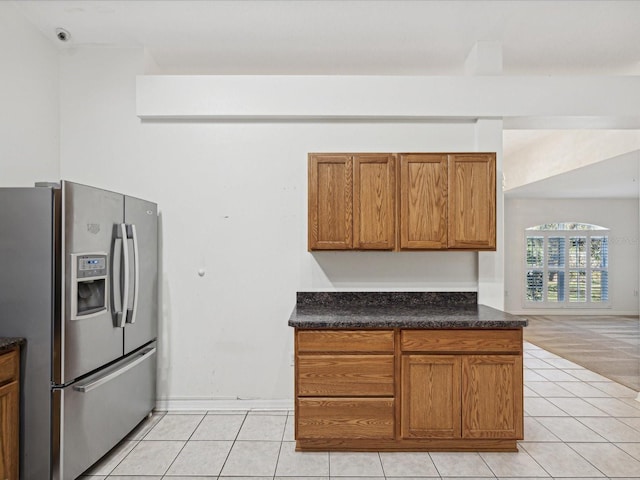 kitchen featuring stainless steel fridge with ice dispenser and light tile patterned flooring