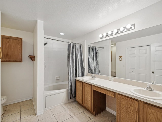 full bathroom with vanity, toilet, tile patterned floors, and a textured ceiling